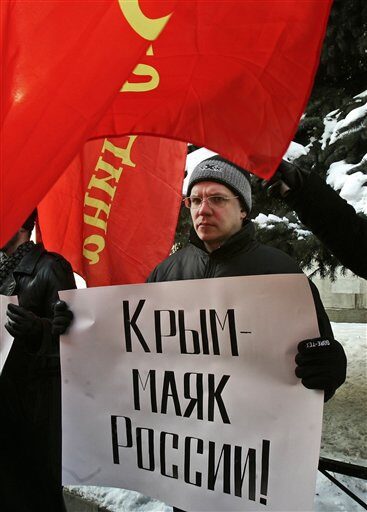 Млад активист държи плакат "Крим е фарът на Русия"