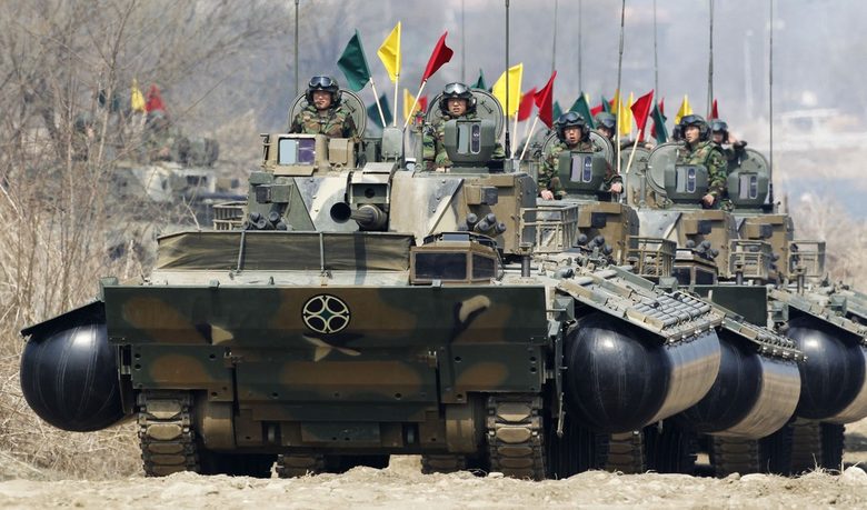 Южнокорейски войници се придвижват с бронирана бойна машина амфибия K21, преди да пресекат река по време на военно учение на 31 март 2011 г.<br />