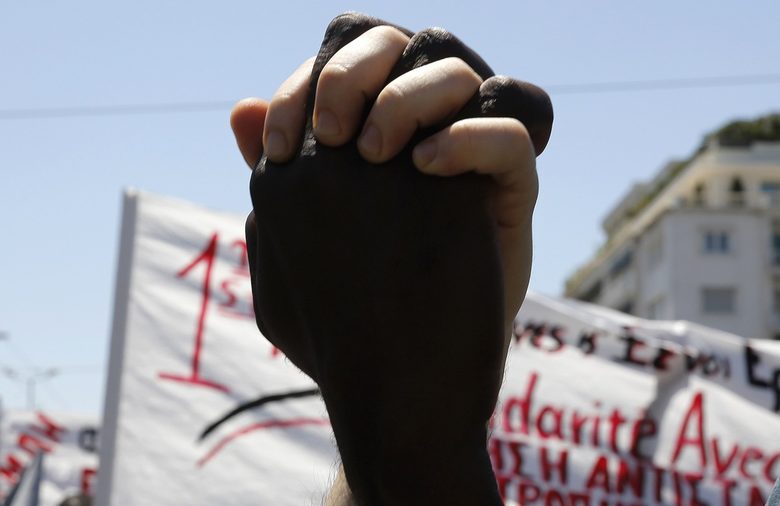 Имигрант от Африка ръка за ръка с грък по време на митинга в Атина.<br />