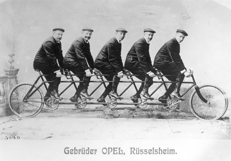Фотография от 1895 година, показваща братята "Опел", на създадения от тях модел с пет седалки, наречен "квинтоплет".