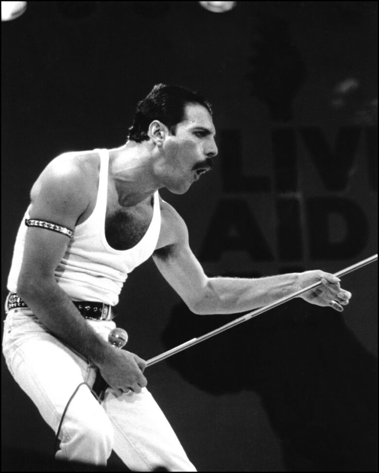 Фреди Меркюри на сцената на стадион "Уембли" по време на Live Aid Фреди Меркюри на сцената на стадион "Уембли" по време на Live Aid