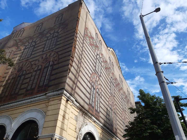 Процеп в паното разкрива, че е сложено, за да предпазва минувачите от падащата мазилка.