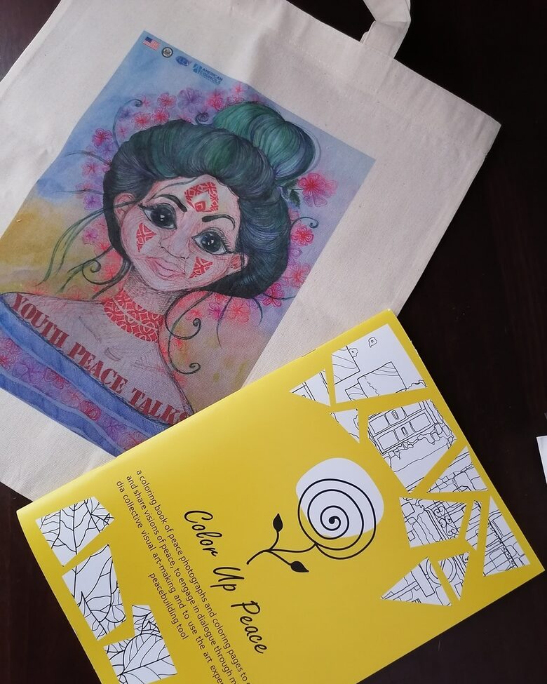 Книжка за оцветяване от проекта Colour Up Peace и торбичка от плат с дизайн на Елизавета Глибченко, изготвена за събитието "Младежки мирни преговори" с участници от цяла Украйна.