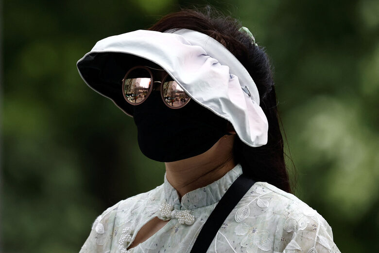 Жена е поставила facekinis маска, покриваща цялото й лице, за да се предпази от получаване на загар от слънцето