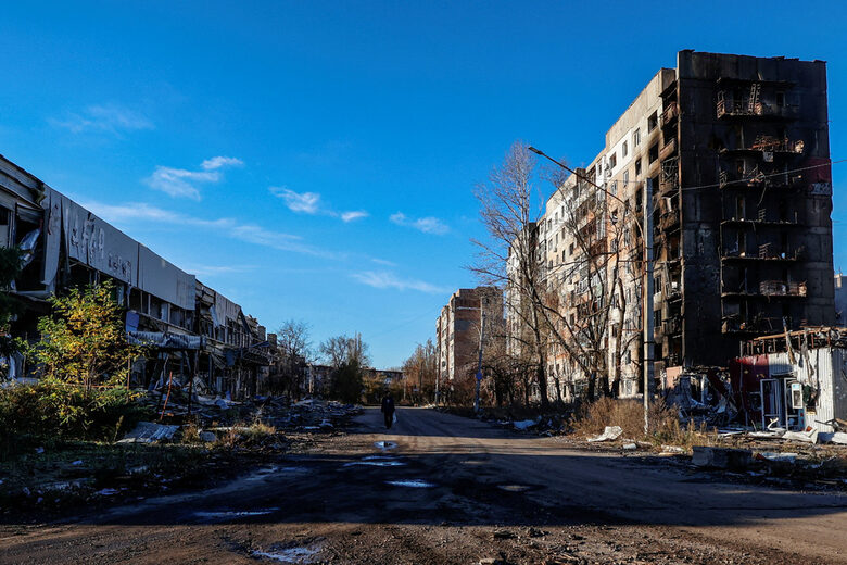 Местен жител се разхожда по една от улиците в град Авдиивка сред разрушените от руските атаки жилищни сгради. 8 ноември 2023 г.