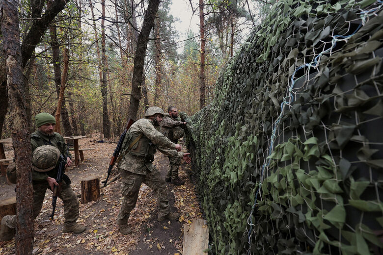 Украински военни прикриват с маскировъчна мрежа самоходна гаубица 2С1 "Гвоздика" на позиция близо до фронтовата линия в Харковска област.