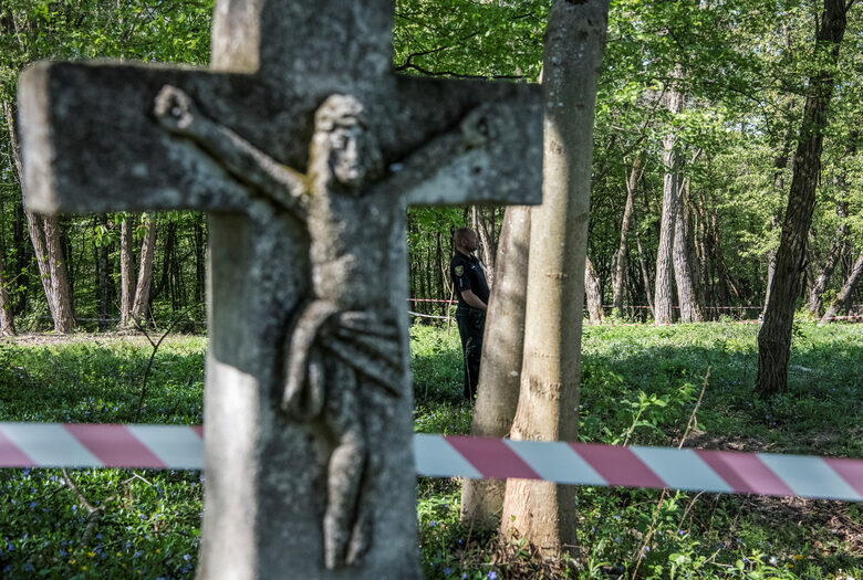 Украински полицай охранява масов гроб на поляци, убити от украински националисти по време на Втората световна война, преди предстоящата ексхумация в бившето полско село Пузники в Тернополска област на Украйна
