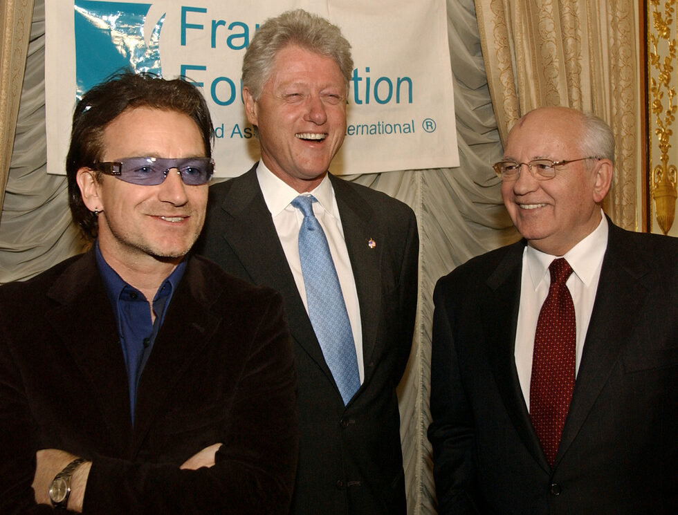 2002г - С вокалиста на рок групата U2 Боно (вляво) и бившия американски президент Бил Клинтън преди благотворителна вечеря в Руското посолство в Ню Йорк в чест на международна фондация за деца. Фондацията помага на деца в неравностойно положение по света, а отскоро и на деца-жертви на атентати