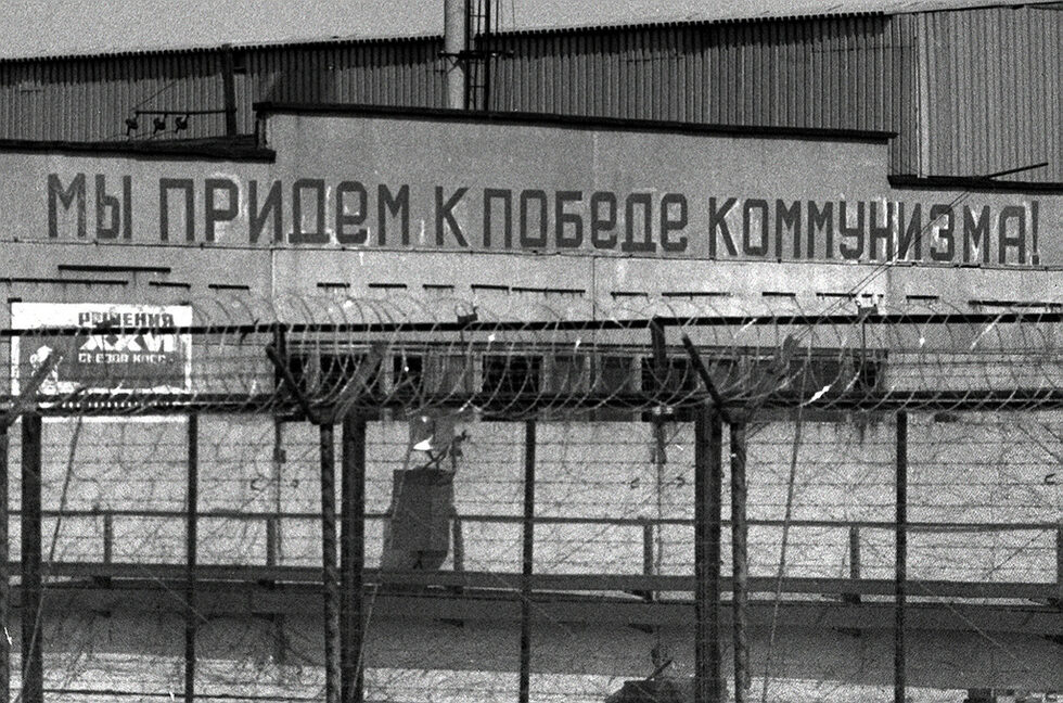 Комунистически лозунг на жилищна сграда в Припят.<br /><br />Увеличаването на онкоболните е другата черна перспектива пред Япония. "Онковзривът" ще стане 5-6 години след трагедията - през 2016-2017 г. По данни на Международната агенция за изучаване на рака около 16 000 души са починали от рак вследствие на аварията в Чернобил. Според Руската академия на науките числата са много по-стряскащи - аварията е причинила смъртта на 140 000 души в Украйна и Беларус и на 60 000 в Русия.