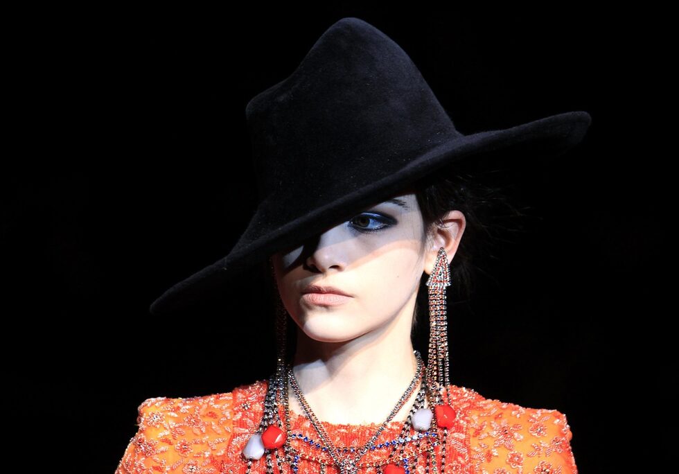Шапката в колекцията на Giorgio Armani е черна, с периферия и задължително стои на една страна, подобно на старите черно-бели криминални филми.