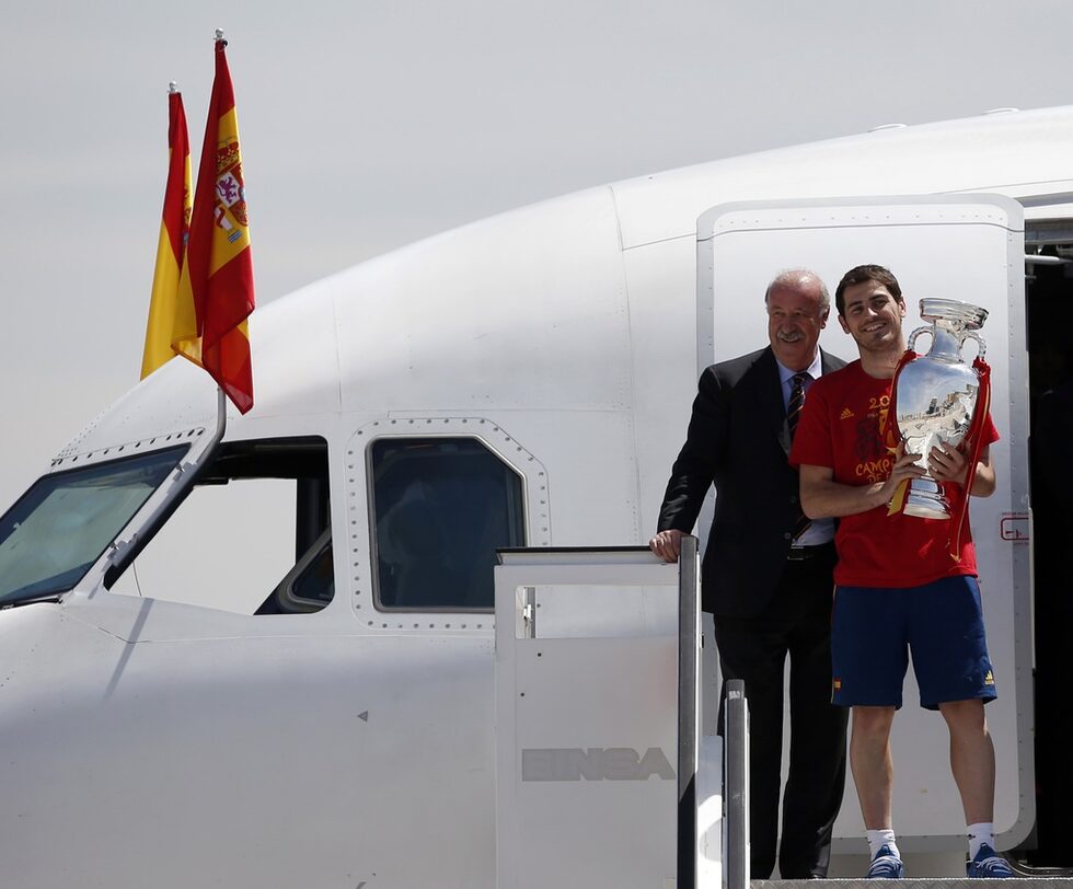 Във финала <a href="http://www.dnevnik.bg/sport/euro2012/2012/07/02/1857276_fotogaleriia_ispaniia_-_stariiat_nov_kral_na_futbolna/">Испания победи Италия с 4:0</a> и спечели историческа трета поредна титла от голямо първенство.<br />
<br />
На снимката: Селекционерът на "Ла Фурия" и капитанът на тима Икер Касияс слизат с европейската купа от самолета, който беше посрещнат на летището под водни стълбове.<br />