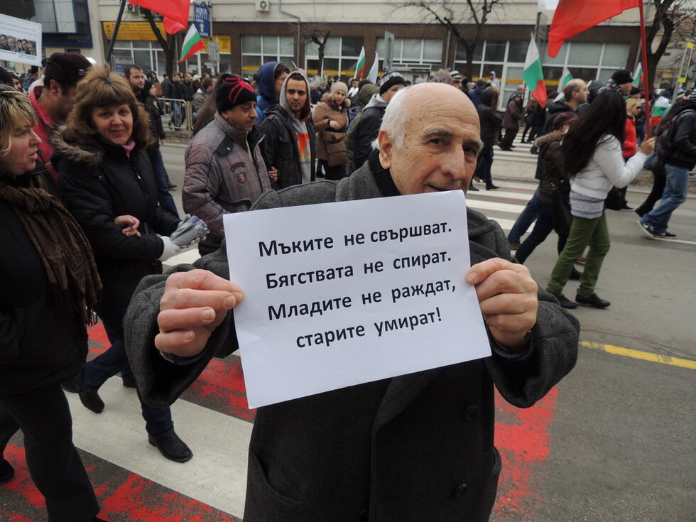 Възрастен мъж спираше пред фоторепортерите, за да покаже миниатюрен плакат с мотивите си за протеста.
