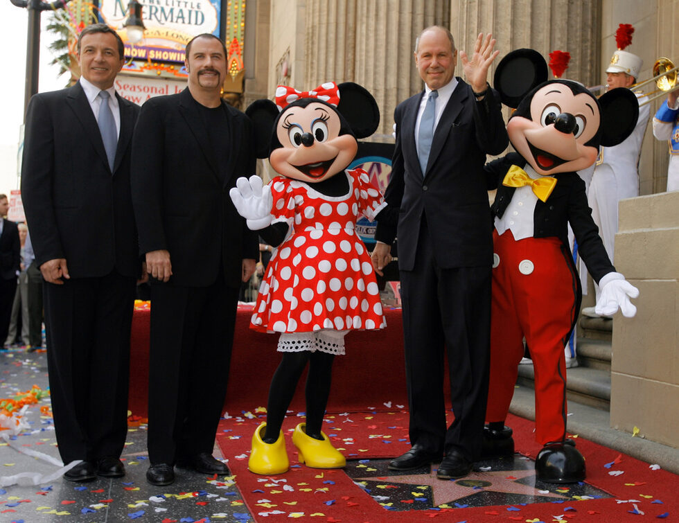 На снимката:<br />
Бившият главен изпълнителен директор на Disney Майкъл Айснър,( втория от дясно), е удостоен със звезда в холивудската Алея на славата в Лос Анджелис,на церемонията присъстваха и изпълнителния директор Боб Игър, и актьорът Джон Траволта.