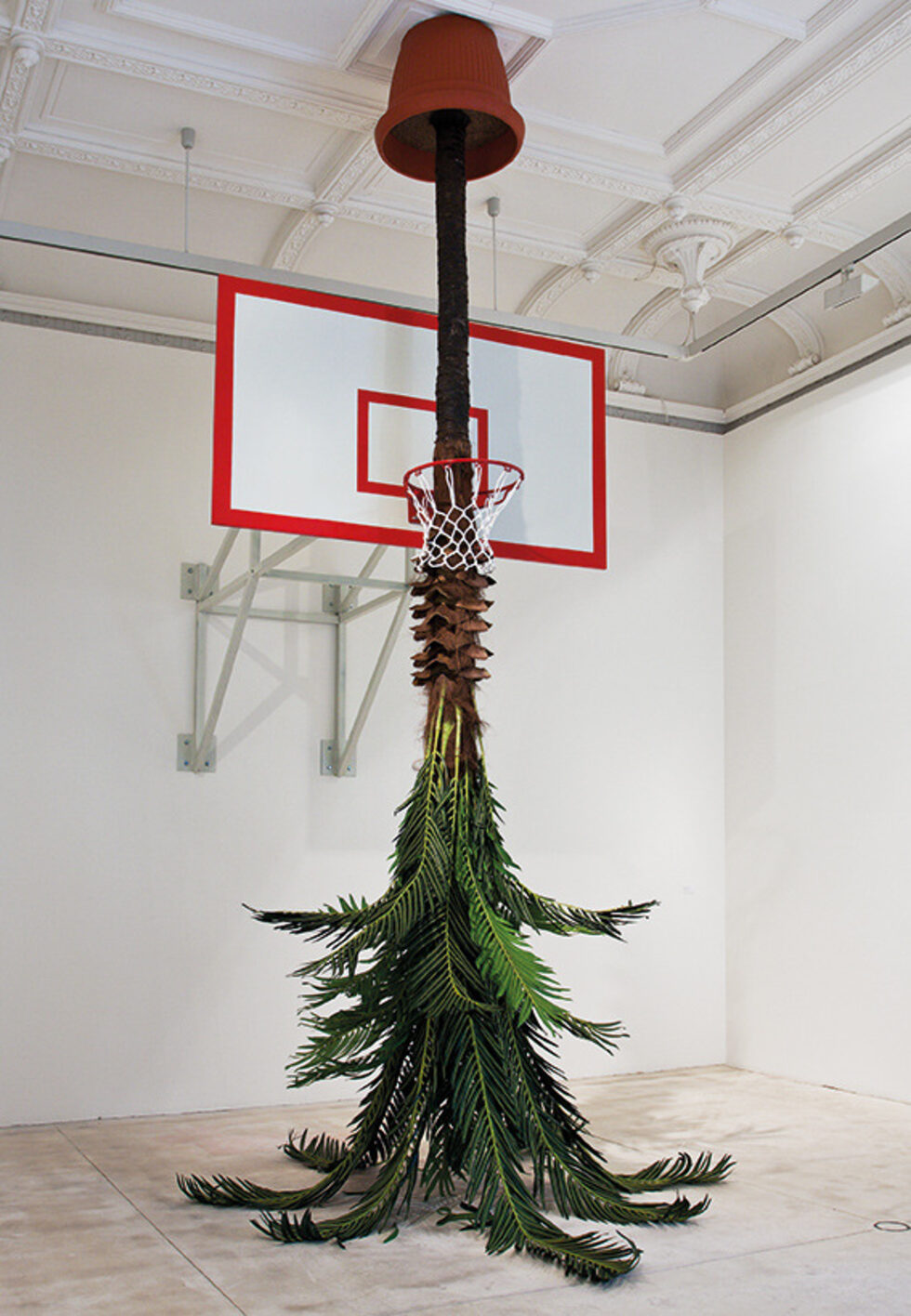 Скочи за да отбележиш, 2011<br />
Метална конструкция, баскетболно табло с кош, изкуствена палма, пластмасова саксия<br />
Височина 480 cm<br />
Галерия Кринцингер, Виена