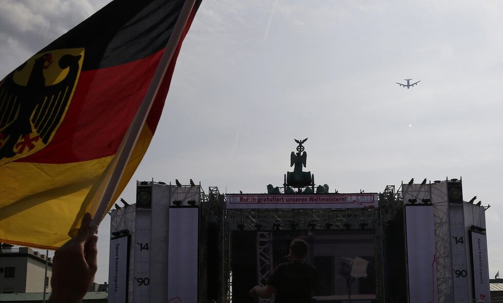 Германският флаг се развява, докато самолетът на националния отбор се подготвя да кацне на летището.
