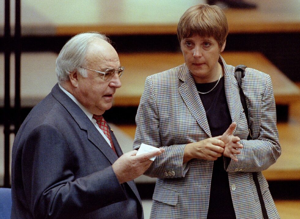 След падането на Берлинската стена, през 1990 г. Меркел работи като говорител на опозиционното движение "Демократично пробуждане", което същата година се влива в Християндемократическия съюз (ХДС). През март 1990 г. Меркел става заместник-говорител на правителството в ДДР на Лотар де Мезиер.<br /><br />На снимката е заедно с канцлера Хелмут Кол.<br />