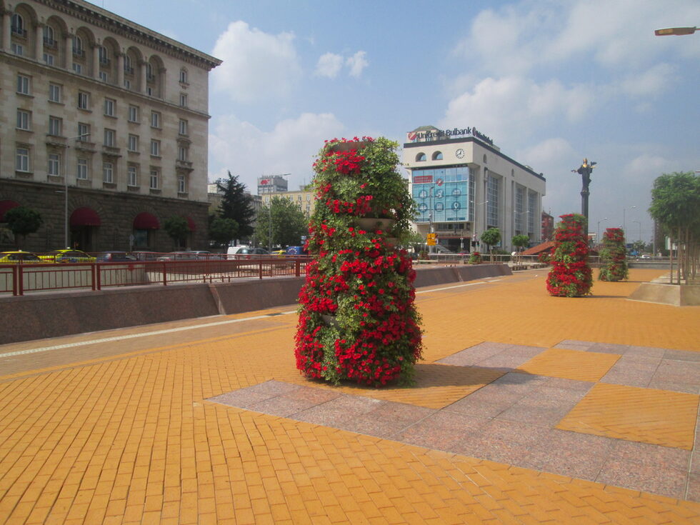 София през лятото, отрупана с цветни кошници.