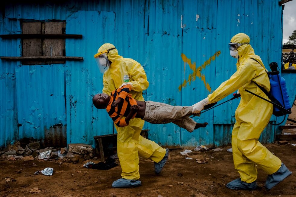 Медици носят 8-годишния Джеймс Дорбър, вероятно болен от ебола, в Монровия, Либерия. Кадърът е на Даниел Берхюлак.<br />