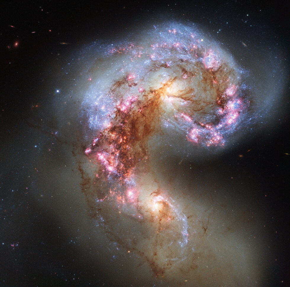 Снимката показва галактиките NGC 4038 и NGC 4039, известни като галактиките Антени. Макар някога те да са били стабилни спирални галактики като Млечния път, през последните стотици милиони години двете галактики се преплипат една в друга. Отдалечени звезди и облаци газ създават дълги "приливни" опашки, които приличат на антени. Очаква се двете галактики да образуват една голяма елиптична галактика.