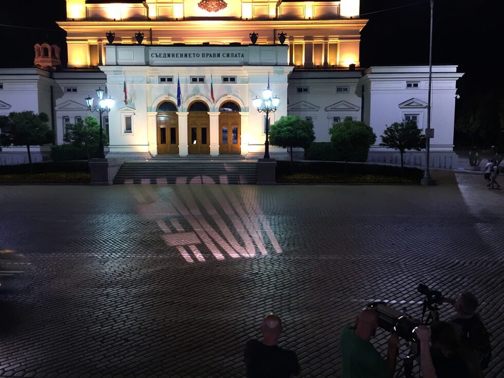 Надписът беше прожектиран и на жълтите павета на площада пред парламента, който в лятото на 2013 г. всяка вечер беше "окупиран" от протестиращи. В нощта на 23 юли 2013 г. на този площад имаше сблъсъци с полицията, която се опитваше да изведе депутати от сградата.