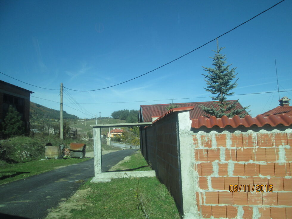 На входа на селището. Новата пътна настилка ще ви отведе до разрушаващо се предприятие.