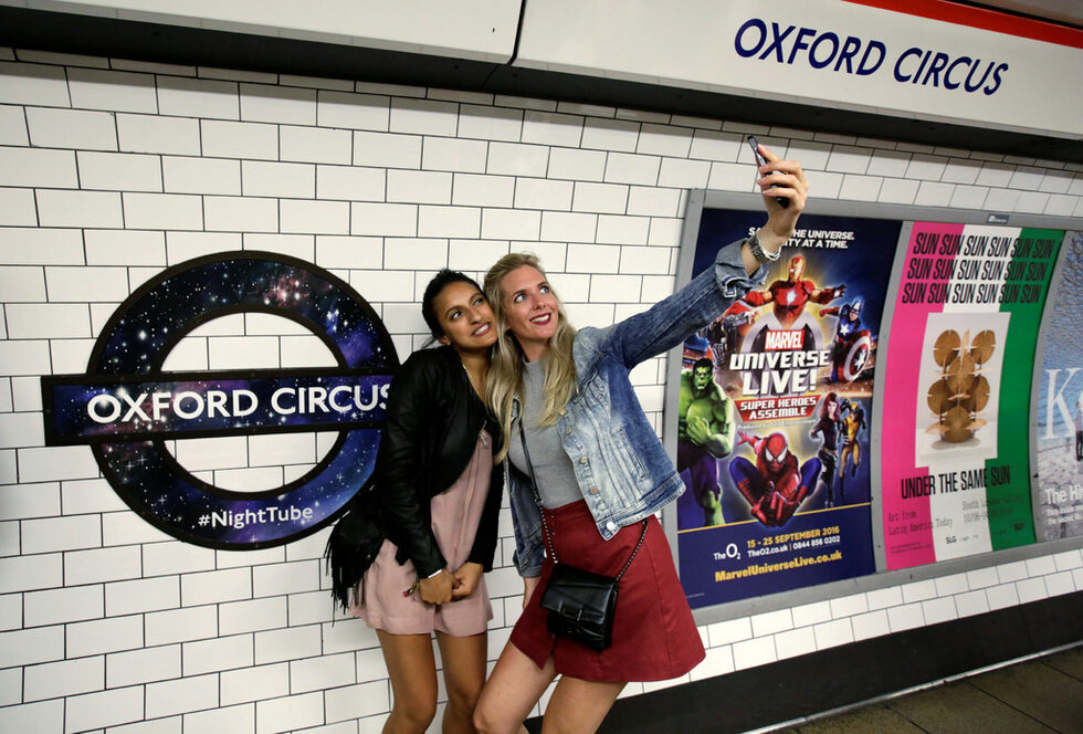 Пътници си правят селфи, докато чакат новата услугата "Night Tube" в лондонското метро в Лондон, Великобритания. От тази седмица <a href="http://www.dnevnik.bg/sviat/2016/08/19/2814215_londonskoto_metro_zapochva_da_raboti_i_noshtem/" target="_blank">лондонското метро започва да работи нощем</a> в петък и събота.