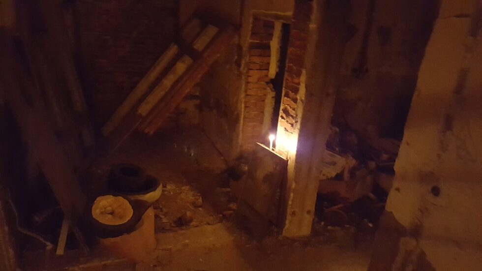 Подът беше от разронен цимент, имаше камъни, стъкла. По ъглите на няколкото стаи имаше купчини с боклуци, пръчки. По разбитите стени имаше графити, стърчаха кабели.