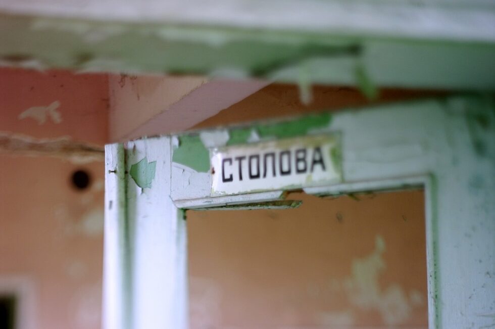 Столовата е огромна, празна, а подът е покрит със сено. 