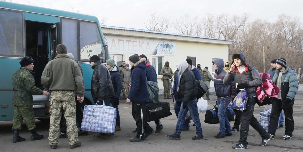 Военнопленници от сепаратистката самопровъзгласила се Луганска народна република (LNR) се качват на автобус по време на размяната на пленници край град Бахмут в региона на Донецк, Украйна.