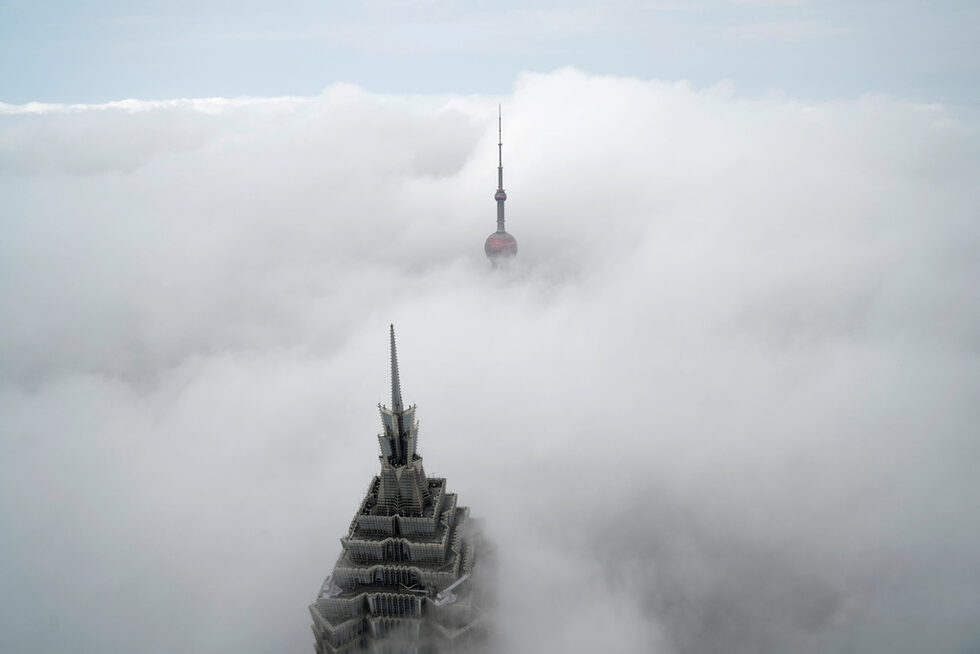 Небостъргачите 'Oriental Pearl Tower и кулата ''Jin Mao Tower'' ( вляво) пробиват мъглата, снимани от Шанхайския световен финансов център в мъглив ден във финансовия район на града.