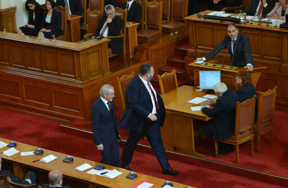 На власт дойде правителството на БСП и ДПС с премиер Пламен Орешарски, а само месец по-късно мнозинството избра депутата от ДПС и бизнесмен Делян Пеевски за шеф на ДАНС, с което отключи най-дългите протести в най-новата история. <br /><br />Цветан Цветанов обяви, че Пеевски контролира прокуратурата. В отговор Пеевски го обвини, че е искал от медиите му информационен чадър за няколко престъпни боса и че е настоявал за назначения пред главния прокурор. От тези сблъсъци остана и заплахата на Пеевски от парламентарната трибуна: "Правораздавателната система ще се занимава, г-н Цветанов, с Вас, за да Ви накаже за всички престъпления, които извършихте."<br /><br />На снимката: 29.05.2013 г. - Делян Пеевски минава пред говорещия от трибуната Цветан Цветанов в деня, когато беше гласуван кабинетът "Орешарски".