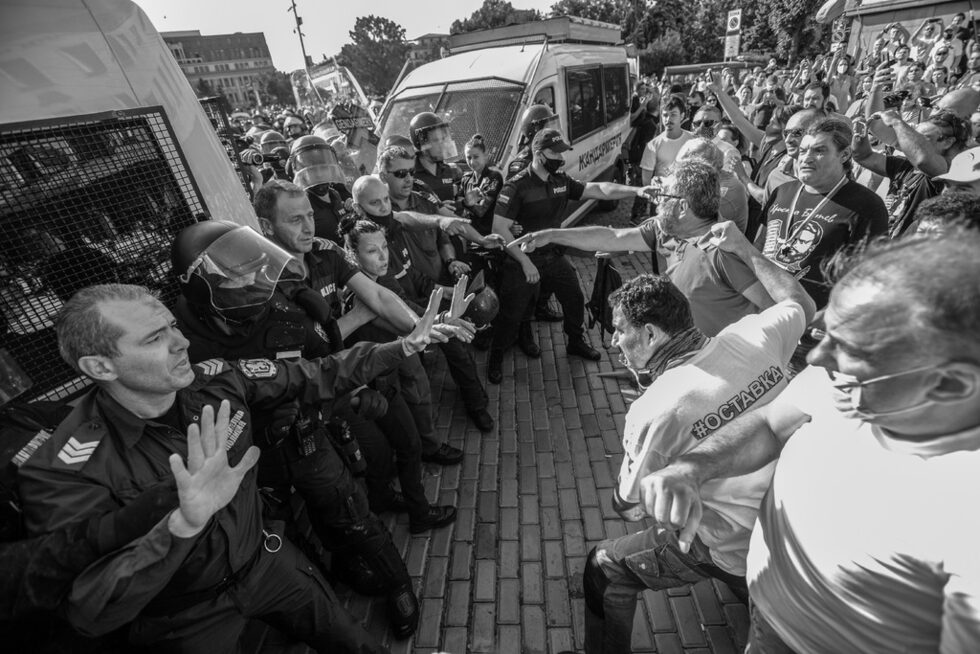 Полицаи успокояват протестиращи, опитващи да преминат през полицейския кордон, за да влязат в сградата на парламента.