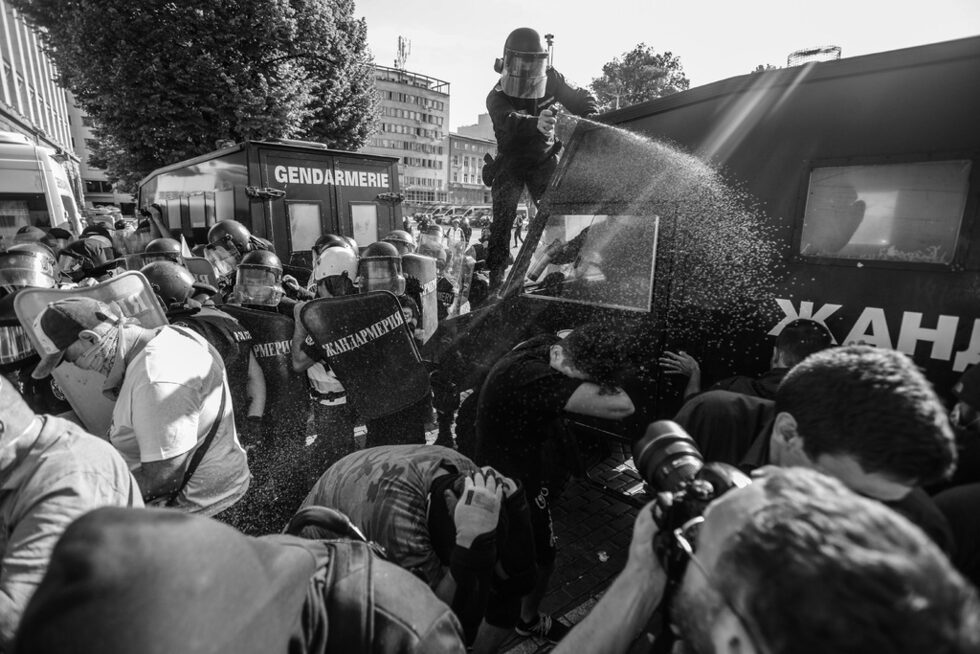 Полицай използва лютив спрей в опит да разпръсне участници в протеста, които се опитват да преобърнат полицейски автомобил.