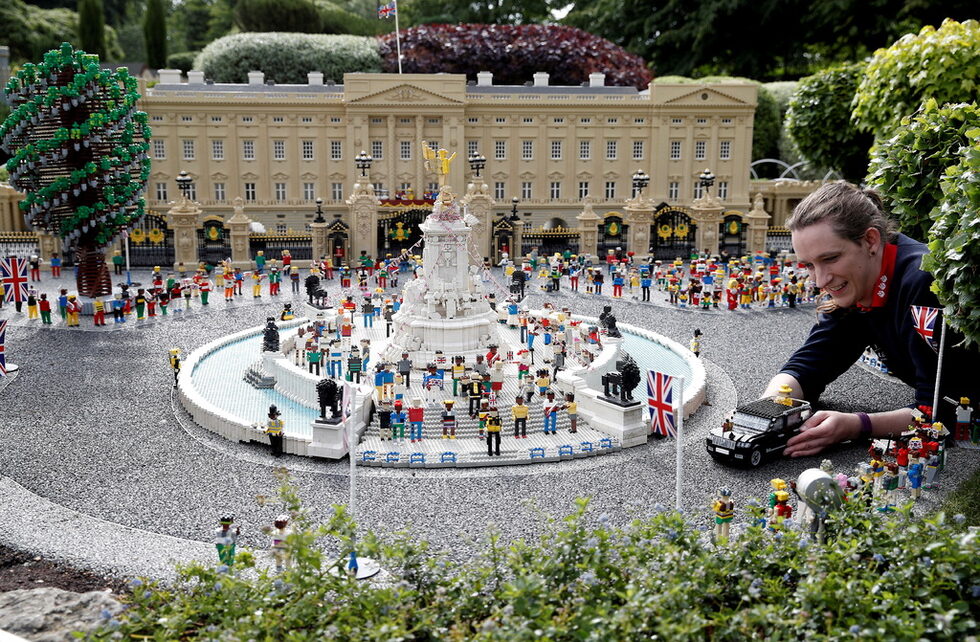 Моделистката на Legoland Фрея Грум позира за снимка, докато поставя модел на британската кралица Елизабет в превозно средство близо до модел на Бъкингамския дворец в Legoland в Уиндзор.