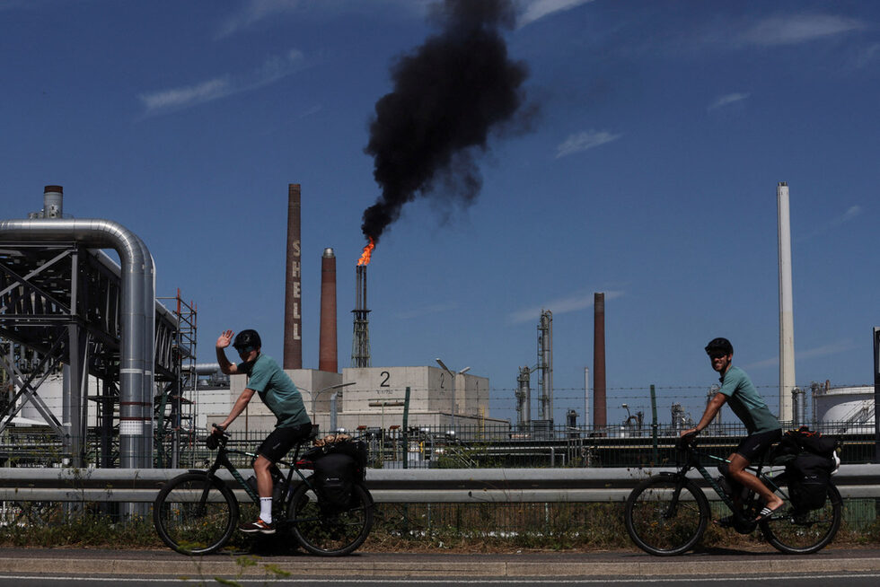 Велосипедисти на път за Сицилия минават покрай рафинерията на Shell Energy and Chemicals Park Rheinland в Годорф близо до Кьолн, Германия