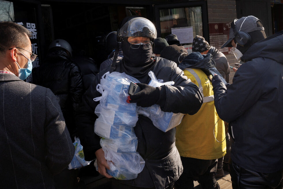 Шофьор на куриерска фирма взема лекарства от аптека в момент, когато в Пекин продължават огнищата на коронавирус.