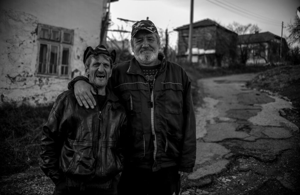И Пламен и Георги подхващат разговор за пътя, по който сме се придвижили. Разхождат ни да видим дупките, да видим къде местните са попълвали с камъни, в опит някак да се оправят сами със ситуацията.<br /><br />"Трябва народът да се обедини, а не да разделят политиките народа", казват Пламен и Георги.<br /><br />В селото няма магазин, от който да си купуват неща от първа необходимост. Веднъж седмично идва мобилен магазин и ако някой от жителите забрави да си купи нещо, трябва да ходи до село Габер, но не всеки има автомобил.<br /><br />На снимката: Пламен и Георги се снимат за спомен на фона на разбития път.