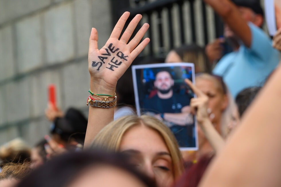 На 26 юни 18-годишното момиче е било нападнато в дома си в Стара Загора - малтретирана и обезобразена е, след като са били нарязани ръцете, краката, гърдите, носът ѝ е счупен, а косата й е била остригана с машинка. Според прокуратурата има нанесени 21 прободни рани, а според разказа на семейството са и направени 400 шева. <br /><br />Обвинен е нейният 26-годишен приятел Георги Николаев Георгиев, който <a href="https://www.dnevnik.bg/bulgaria/2023/07/31/4513344_obvineniiat_za_obezobrazenoto_momiche_v_stara_zagora/" target="_blank">отново е в ареста и остава под стража</a>, но по друго обвинение от неделя (30 юли) за заплахи за убийство към нападнатата.<br /><br />На снимката: Протеста в София