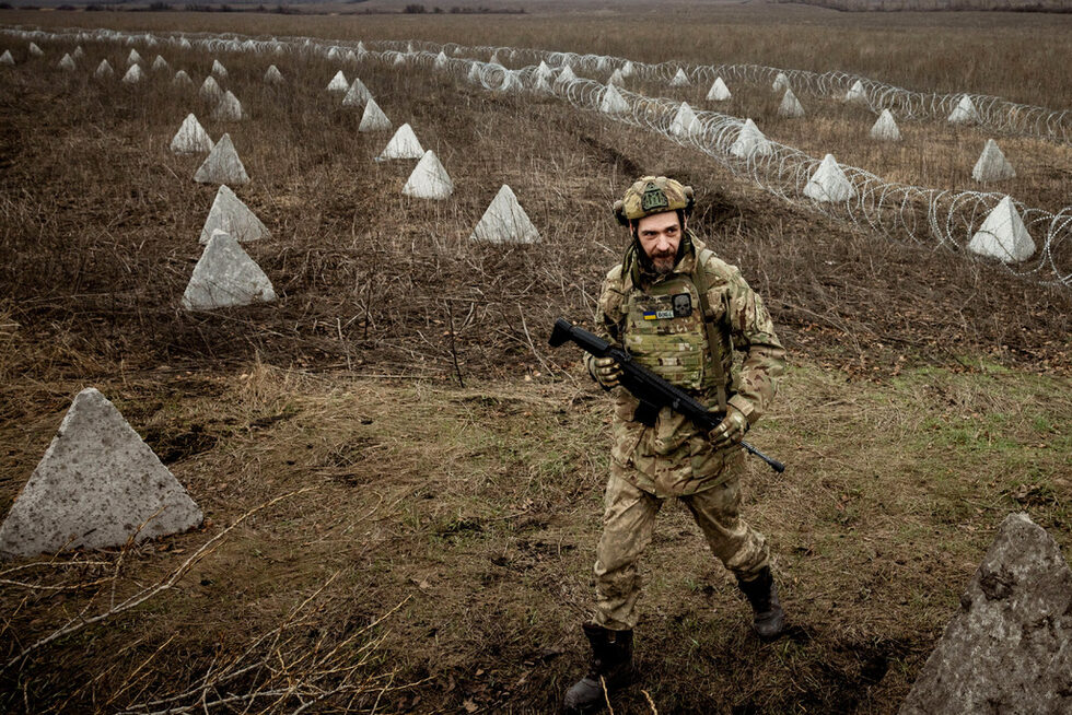 Украински военен инженер с позивна "Гущер" върви близо до укрепления, включително "драконови зъби" и бодлива тел, които той помогна да бъдат построени в поле близо до фронтовата линия край Купянск.