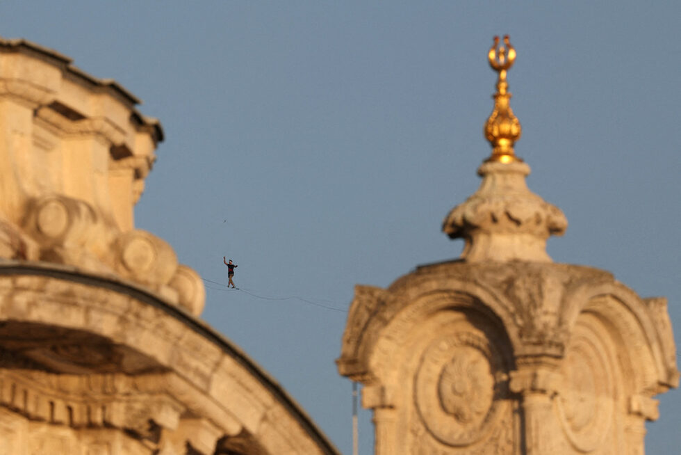 Естонският атлет Яан Руз е сниман зад Ортакьой джамия, докато върви по въже по Моста на мъчениците от 15 юли, известен като Моста над Босфора, който преминава от азиатската към европейската страна на града, в Истанбул, Турция.