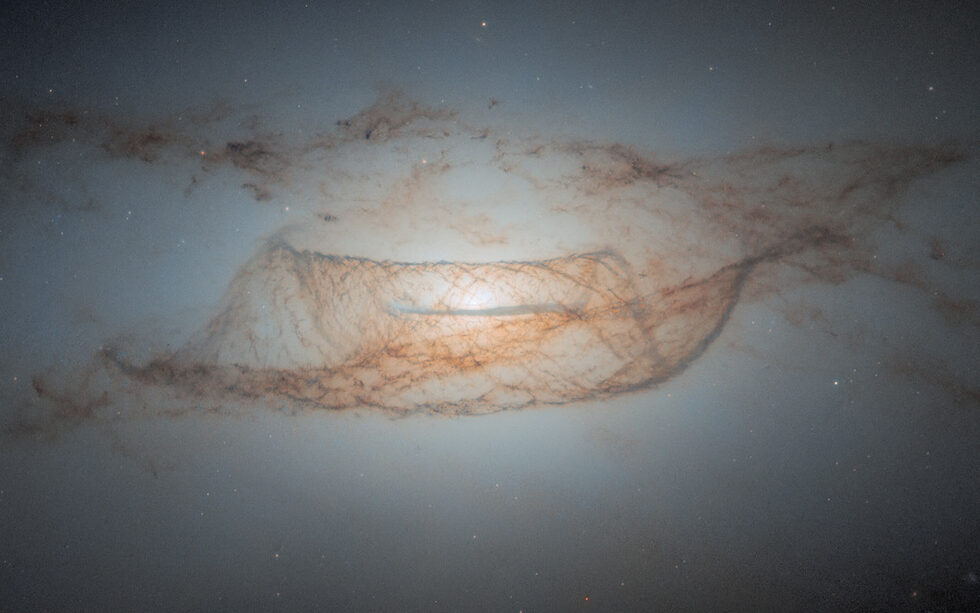 Снимка на лещовидната галактика NGC 4753, направена от космическия телескоп "Хъбъл" на 20 май 2024 г. NGC 4753 се намира на около 60 милиона светлинни години от Земята в съзвездието Дева. Тя е член на Групата галактики NGC 4753 в Облака Дева II, който се състои от около 100 галактики и галактични купове.<br /><br />Смята се, че тази галактика е резултат от галактическо сливане с близка галактика джудже преди около 1.3 млрд. години. По-голямата част от масата на галактиката се намира в леко сплескан сферичен ореол от тъмна материя.
