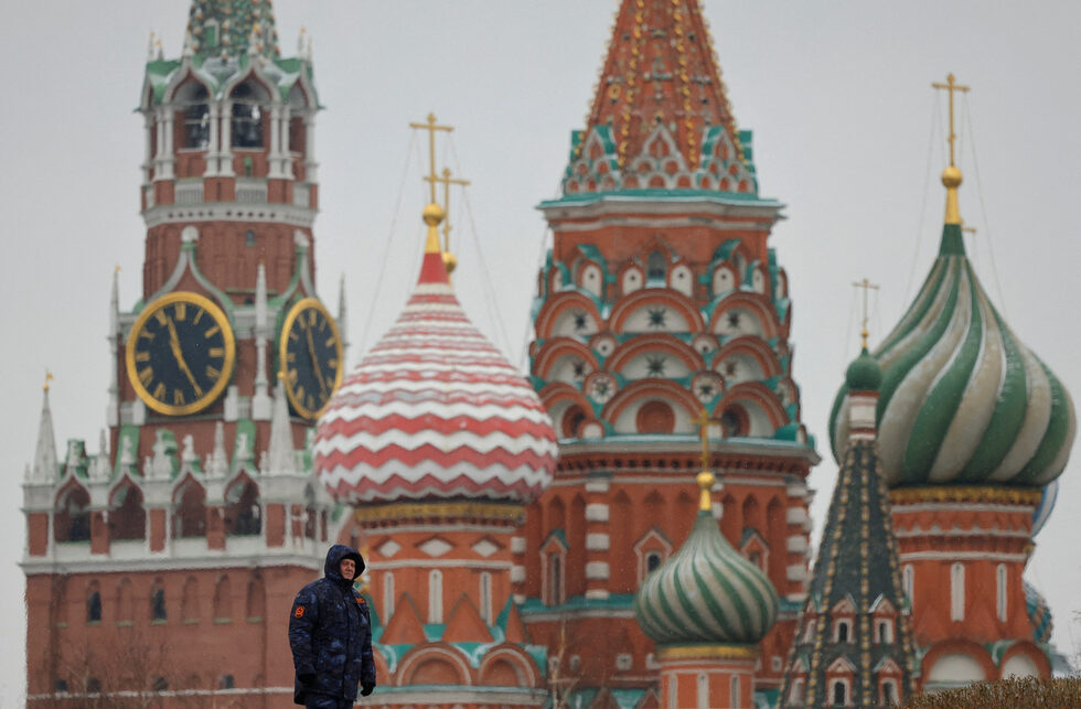 Специалист по сигурността стои на стража до Спаската кула на Кремъл и катедралата "Свети Василий" в центъра на Москва, Русия