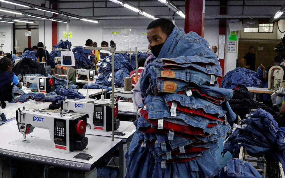 Кенийски работник носи дрехи за износ във фабриката на United Aryan Export Processing Zone (EPZ), работеща по американския Закон за африканския растеж и възможности (AGOA), в квартал Руарака на Найроби, Кения.