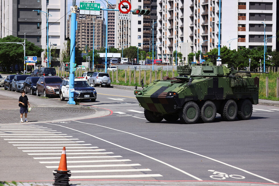 Мъж чака да пресече улица, докато бронирано превозно средство CM-34 "Облачен леопард" участва в учение, симулиращо нападение от Китай, в градска среда като част от годишните маневри Хан Куанг, в Нов Тайпе, Тайван.
