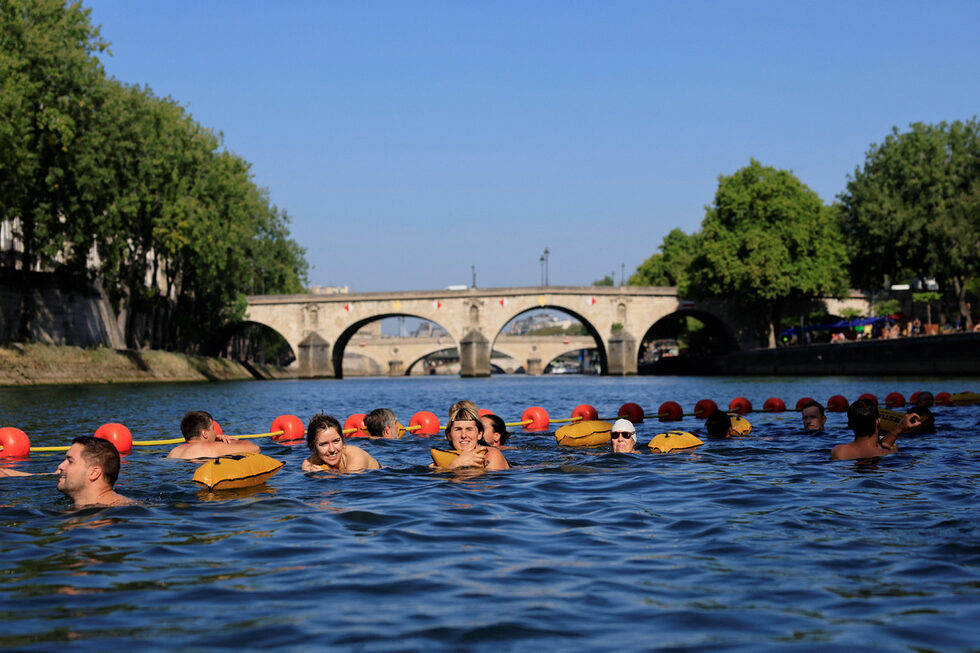 Хора плуват във водите на река Сена, Париж, Франция.