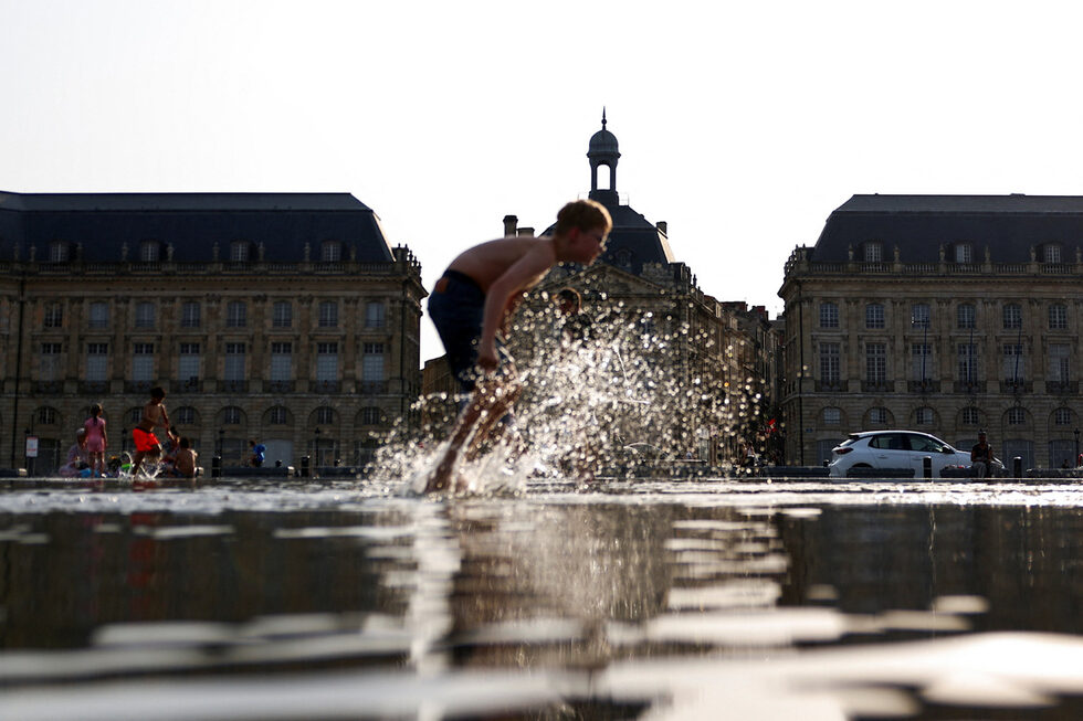 Дете си играе във водата на Miroir d'eau, за да се разхлади, по време на горещата вълна в Бордо, Франция.