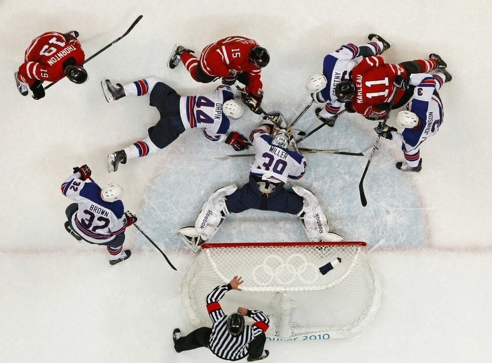 Хокеистите на <a href="http://www.dnevnik.bg/sport/2010/02/22/862857_zaguba_s_tejestta_na_dve_za_kanada_v_hokeia_na_led/">САЩ победиха с 5:3 Канада</a> в деня на дербитата в олимпийския турнир. Домакините разочароваха привържениците си и бяха надиграни, макар специалистите да ги определяха за фаворити.<br />
<br />
На снимката: Вратарят на американците Райън Милър спасява в борба за шайбата с канадците Джо Торнтън, Дани Хитли и Патрик Марльо